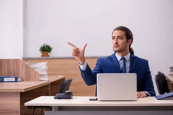 Junger Mann sitzt am Arbeitsplatz — Stockfoto