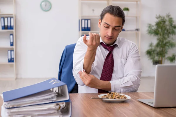 Hongerige mannelijke werknemer die boekweit eet tijdens de pauze — Stockfoto