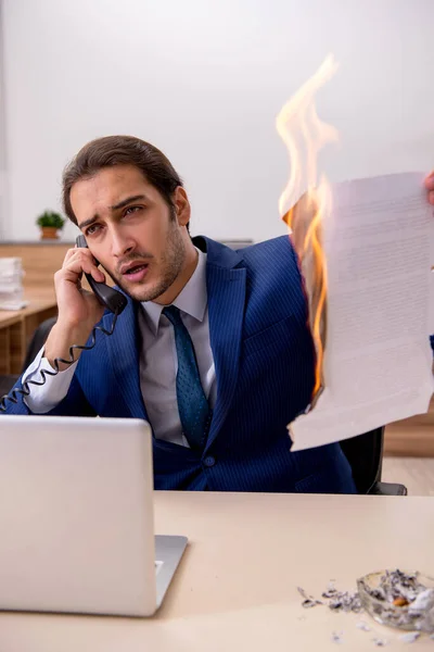 Junge männliche Angestellte verbrennt Papiere im Büro — Stockfoto