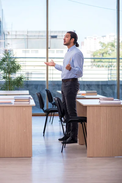 Young male teacher in the classroom — Stock Photo, Image