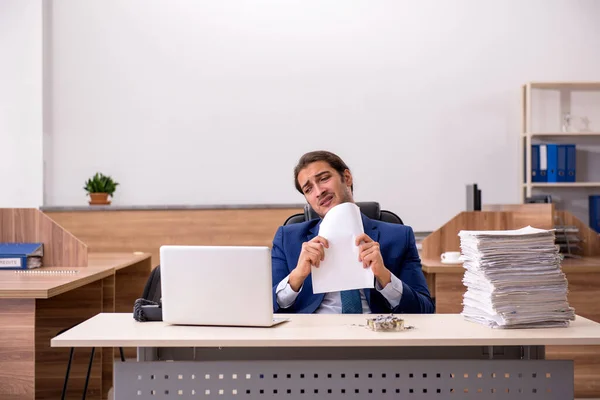 Young man employee reading contract at workplace — Stock Photo, Image