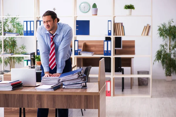 Joven empleado masculino infeliz con el trabajo excesivo —  Fotos de Stock