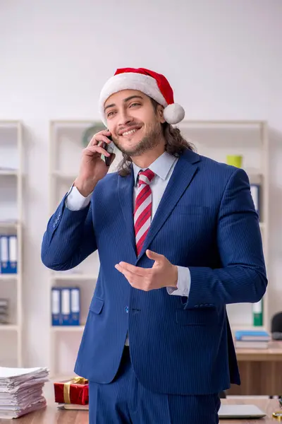 Young male employee working in the office at Christmas Eve — Stock Photo, Image