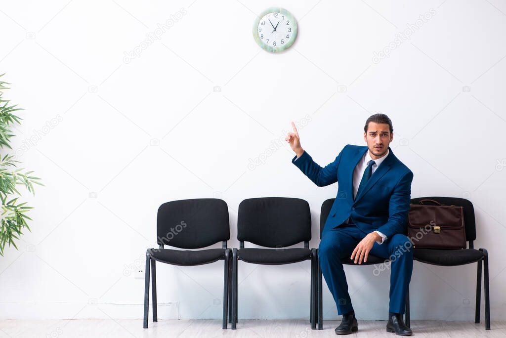 Young businessman waiting for an interview at hall