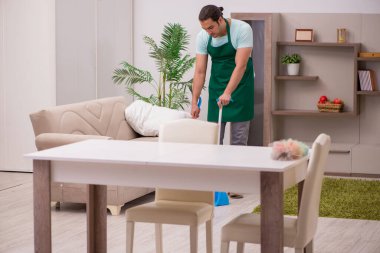 Genç erkek müteahhit evi temizliyor.