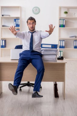 Genç işadamı ofisteki aşırı işten memnun değil.