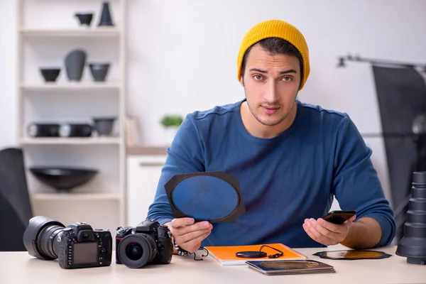 Mladý muž fotograf pracující ve studiu — Stock fotografie