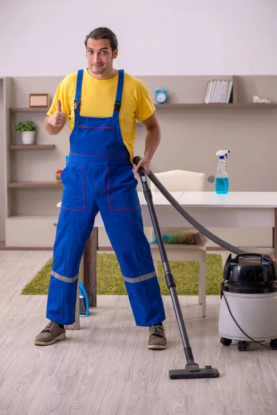 Jovem empreiteiro limpando a casa — Fotografia de Stock