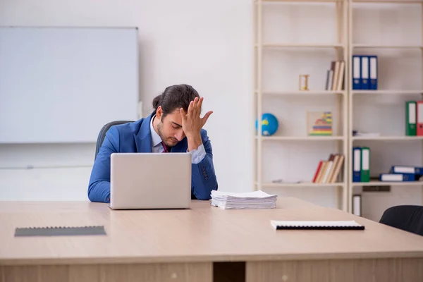 Ung manlig anställd som sitter på kontoret framför whiteboard — Stockfoto