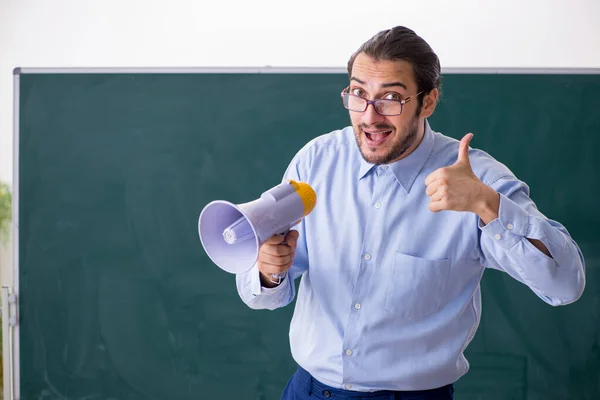 Junger männlicher Lehrer im Klassenzimmer mit Megafon — Stockfoto