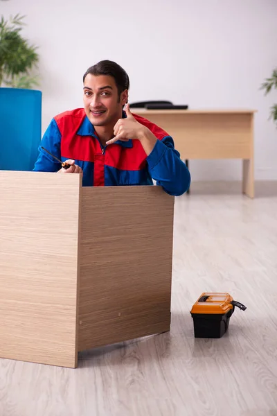 Ung manlig entreprenör reparera möbler på kontoret — Stockfoto