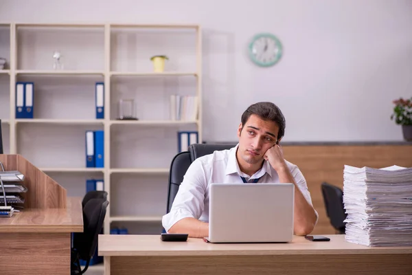 Jonge mannelijke werknemer ongelukkig met overmatig werk in het kantoor — Stockfoto