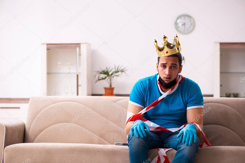 Young man with crown on head at home