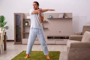 Genç adam evde spor yapıyor.