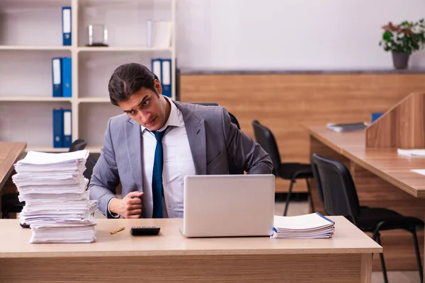 Jovem funcionário masculino infeliz com excesso de trabalho no escritório — Fotografia de Stock