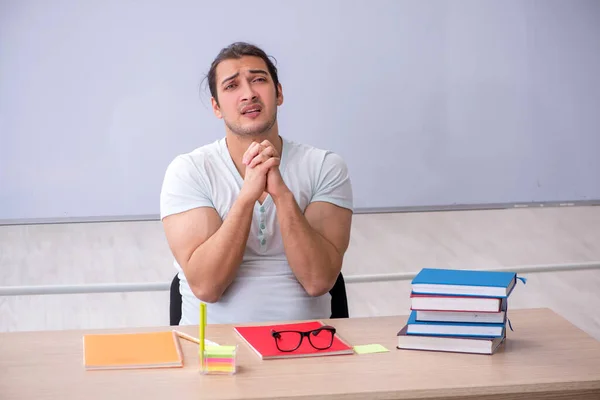 Junge männliche Lehramtsstudentin sitzt im Klassenzimmer — Stockfoto