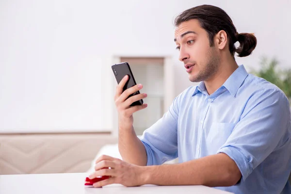 Joven hombre feliz con teléfono inteligente haciendo propuesta de matrimonio — Foto de Stock