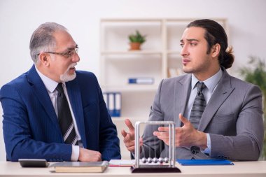 Masada iki iş adamı ve meditasyon topu var.