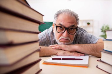 Sınav hazırlıkları sırasında yorgun düşen yaşlı bir erkek öğrenci.