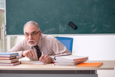 Sınıftaki yaşlı erkek öğretmen.