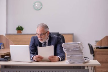 Ofiste çalışan yaşlı bir erkek.