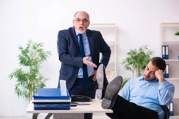 El viejo jefe y su joven asistente en la oficina —  Fotos de Stock