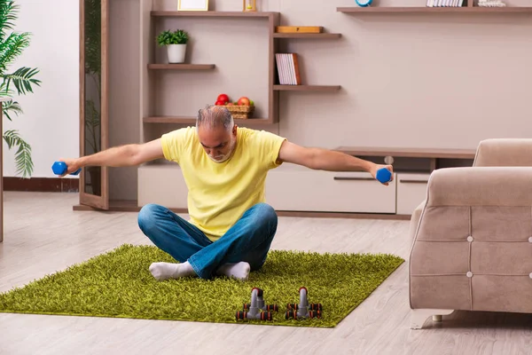 Hombre anciano haciendo ejercicios deportivos en casa — Foto de Stock