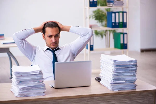 Jovem funcionário do sexo masculino infeliz com trabalho excessivo — Fotografia de Stock