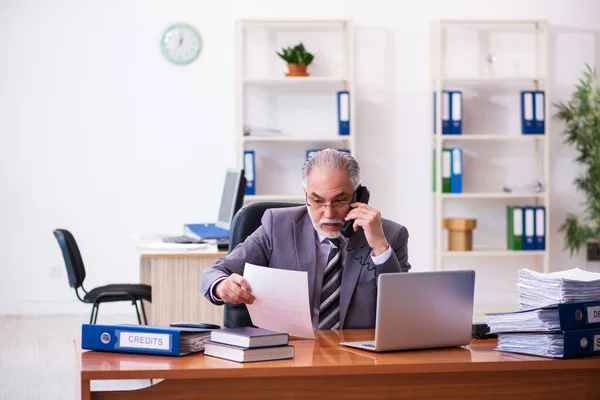 나이가 많은 사업가가 사무실에서 계약서를 읽고 있다 — 스톡 사진