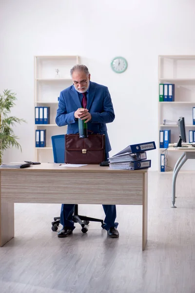 Un vieil employé boit de l'alcool au bureau — Photo