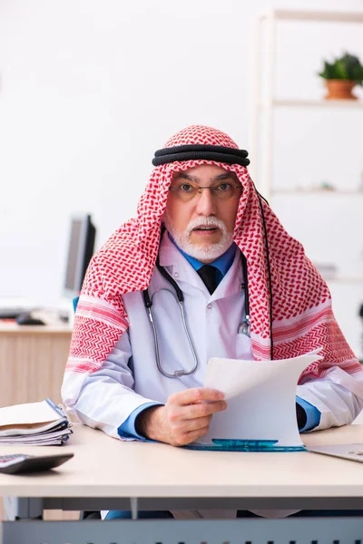 Starý mužský arabský lékař pracující na klinice — Stock fotografie