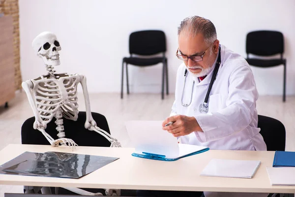 Anciano médico y paciente esqueleto en la clínica —  Fotos de Stock