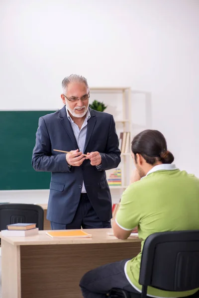 Professor idoso e jovem estudante do sexo masculino em sala de aula — Fotografia de Stock