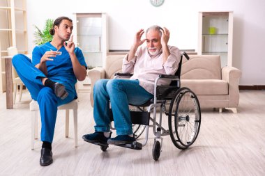 Tekerlekli sandalyedeki yaşlı adam ve genç kötü bakıcı.