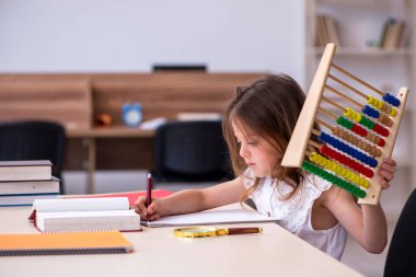 Evde sınava hazırlanan küçük kız.