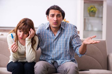 Evde beklenmedik hamilelik konsepti olan genç bir çift var.