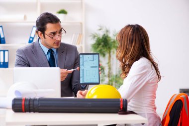 Genç işadamı ve bayan mimar yeni projeyi tartışıyor