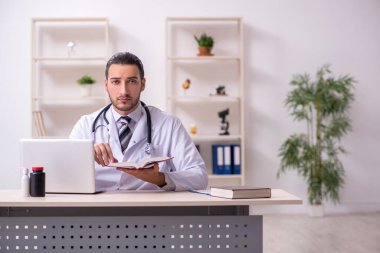 Klinikte çalışan genç erkek doktor.