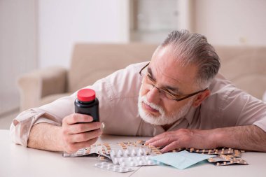 Yaşlı hasta adam evde acı çekiyor.