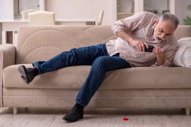 Yaşlı hasta adam evde acı çekiyor.