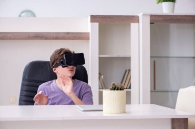 Okullu çocuk evde sanal gözlük takıyor.