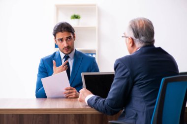 Genç bir erkek aday, yaşlı bir askerle görüşüyor.