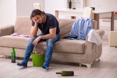 Evde midesi ağrıyan genç bir alkol bağımlısı.