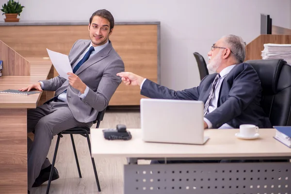 Oude baas en jonge mannelijke assistent in het kantoor — Stockfoto