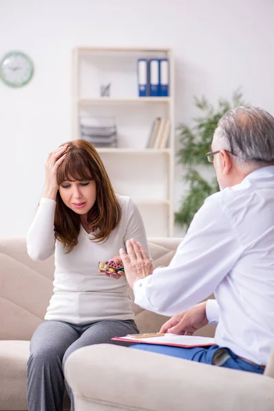 Mujer joven visitando viejo médico psicólogo — Foto de Stock