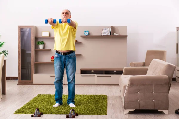Aged man doing sport exercises at home — Stock Photo, Image