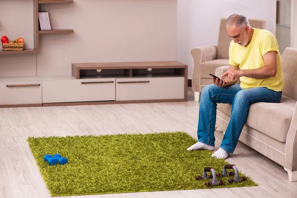 Homme âgé faisant des exercices sportifs à la maison — Photo