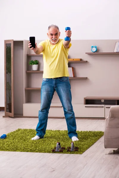 Homme âgé faisant des exercices sportifs à la maison — Photo