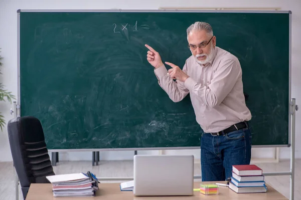 Velho professor sentado na sala de aula — Fotografia de Stock