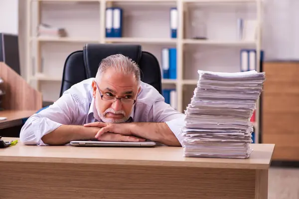 Ofisteki aşırı işten memnun olmayan yaşlı bir erkek işçi. — Stok fotoğraf